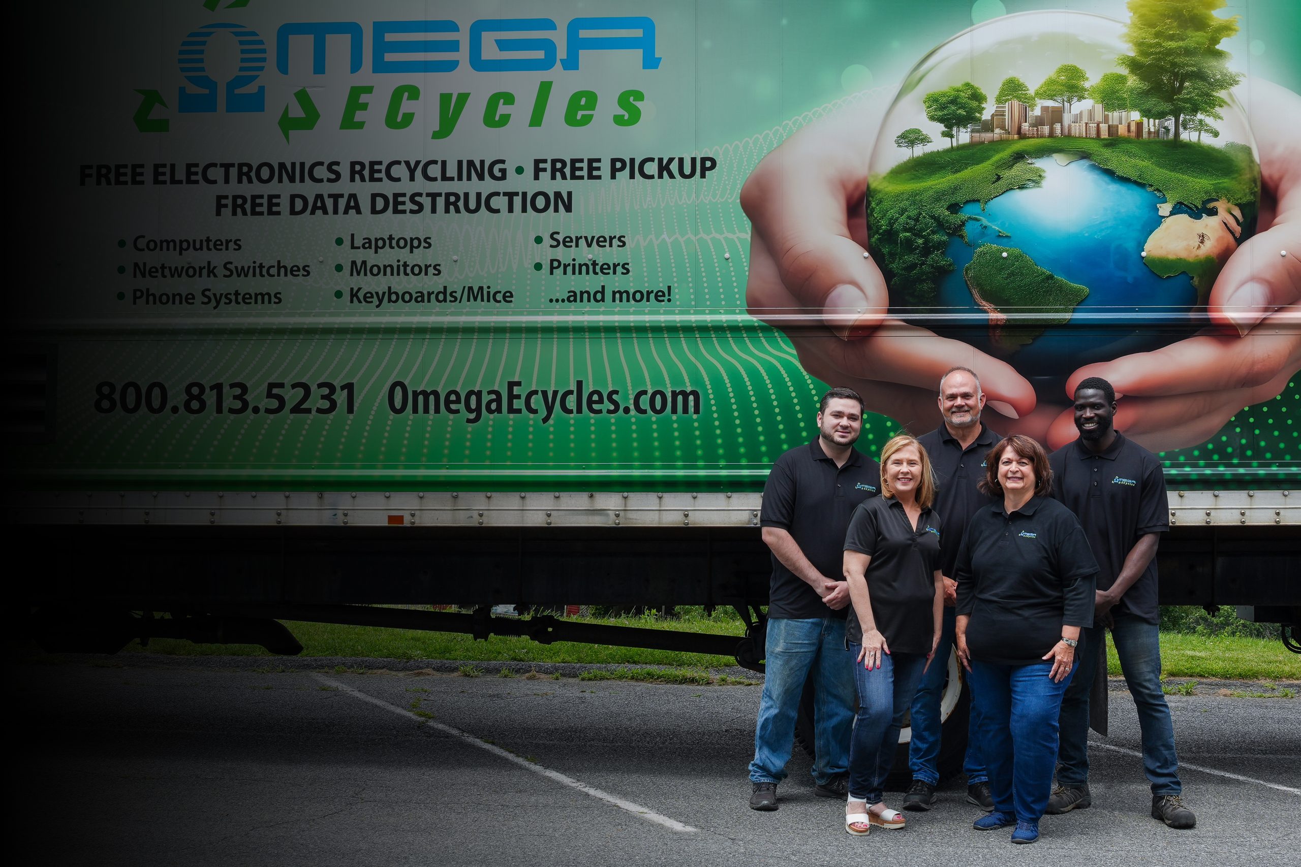 Five people in matching black shirts stand smiling in front of an "Omega ECycles" truck offering No Cost Electronics Recycling, pickup, and data destruction in Central PA. The truck features a green, eco-friendly design.